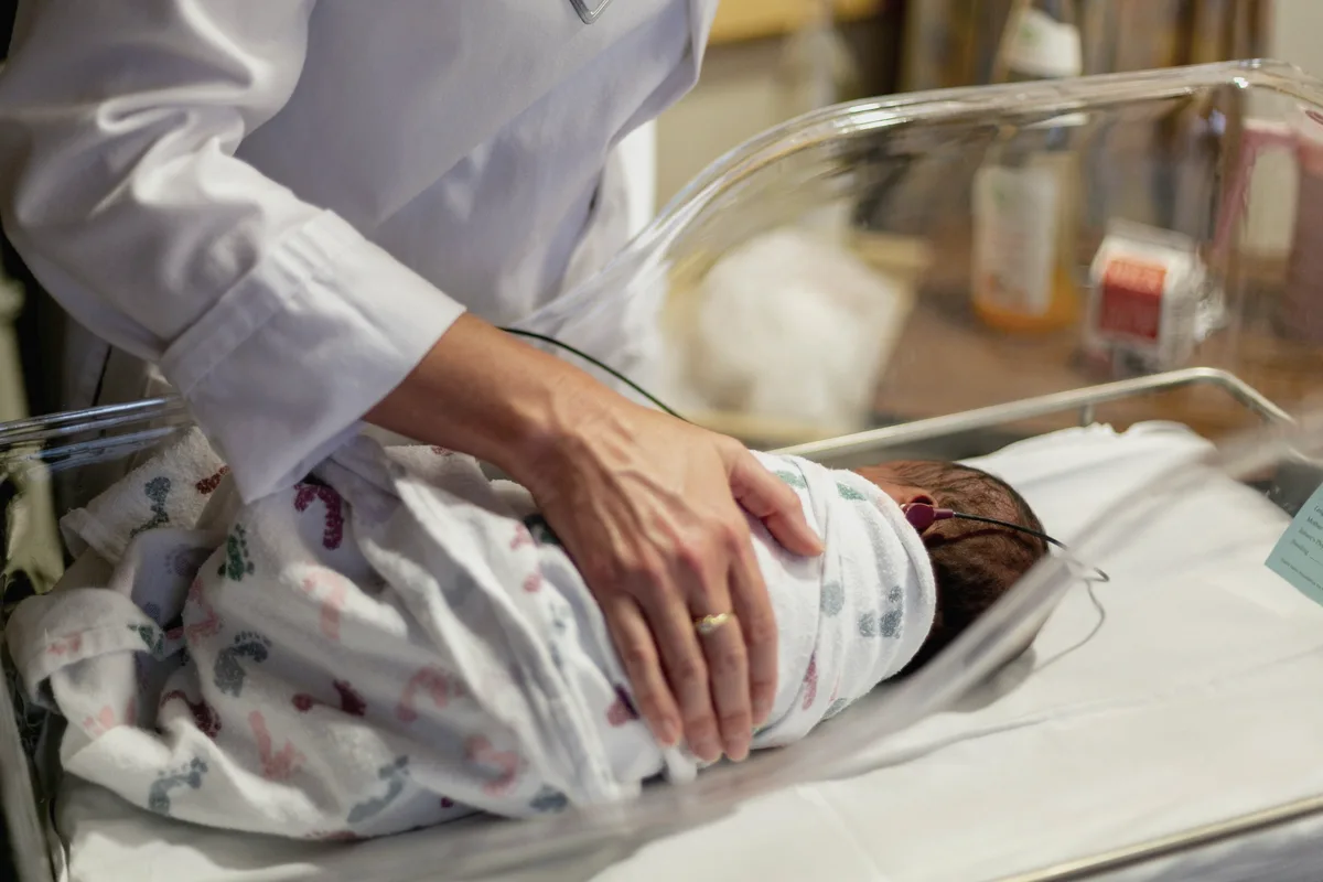 Newborn being cared for in a hospital bassinet after birth